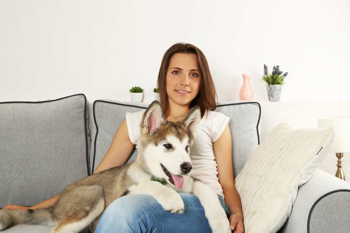 Woman Sitting with Dog on Sofa 